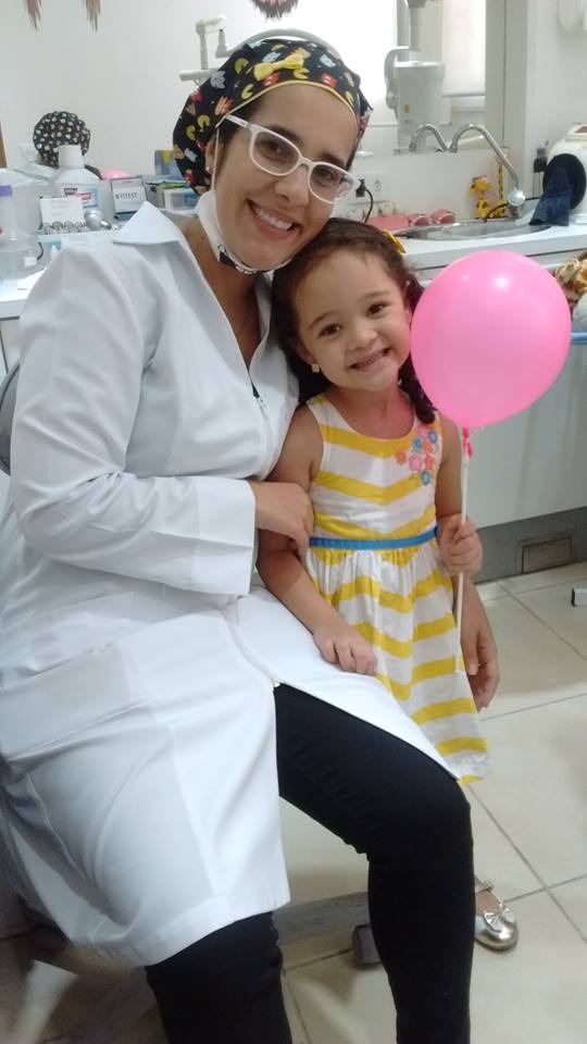 Paciente sorrindo na cadeira do consultório.